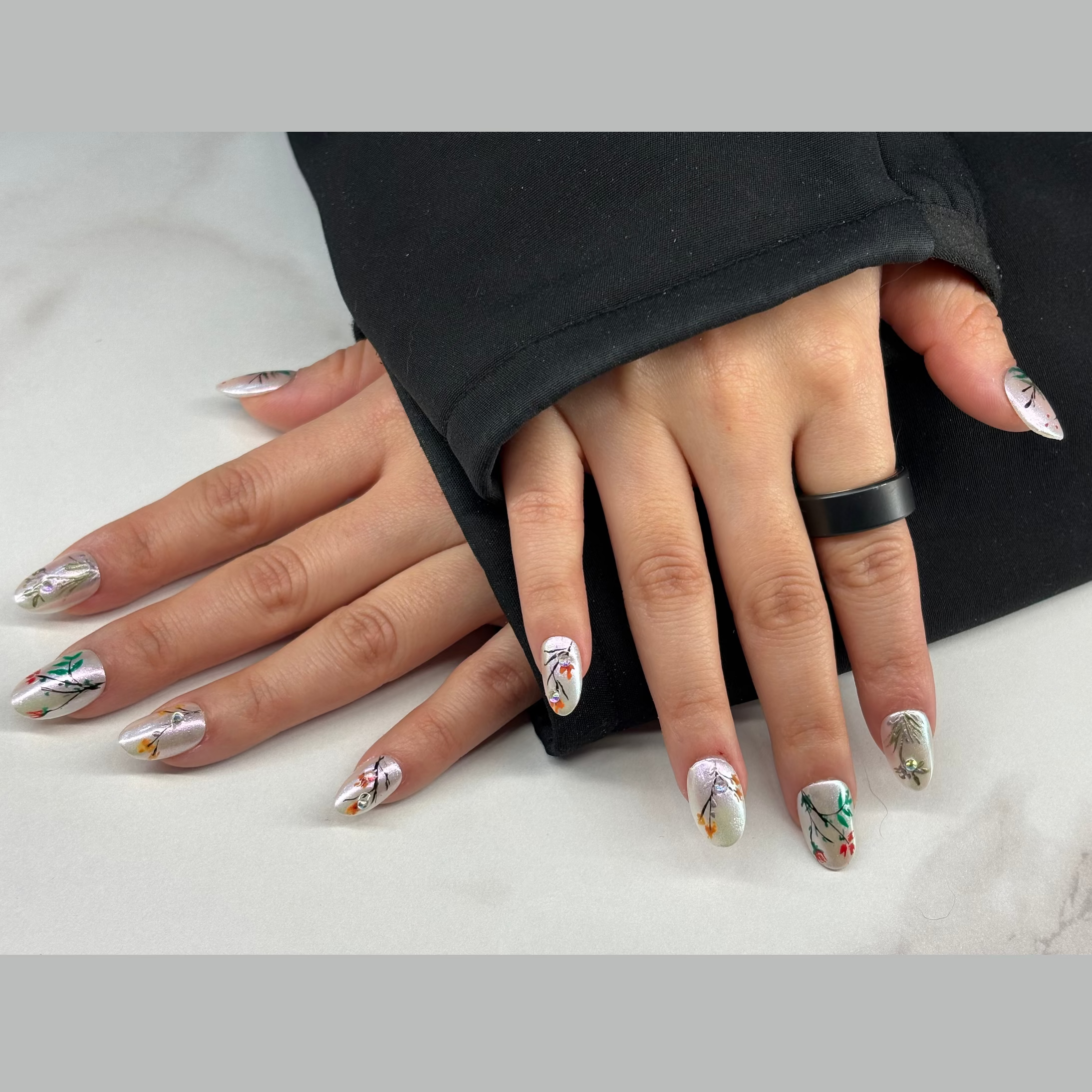 A milky white base with pearl finish gives it the muse of a Chinese garden. We’ve hand-painted thin, dark stems and small colorful buds across the nails to mimic early spring growth. A few small crystals are added to catch the light, like water droplets. It’s a simple, honest design for those who want a professional look that feels light and seasonal.