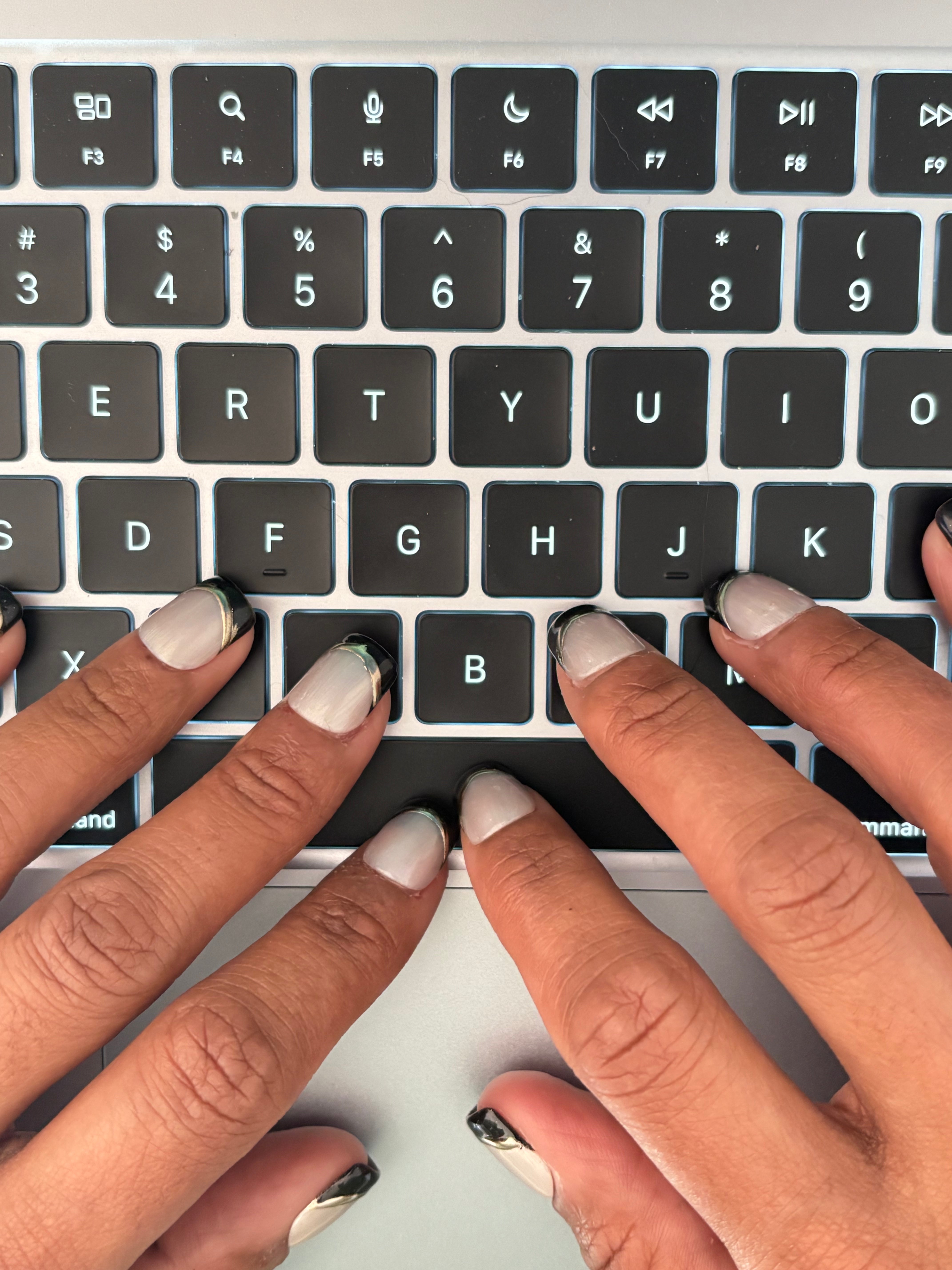 A study in structured contrast. This set features a luminous, cat-eye base framed by a deep onyx French tip. A hand-rendered gold border defines the edge, offering an architectural finish for those who value intentional, quiet luxury.